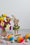 Funny wooden Easter bunny and rainbow Easter eggs with spring flower