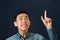 Funny young Asian man pointing his index finger up