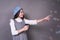 Funny young caucasian lady in a stylish blue hat in a beret, with soap balls on a gray background