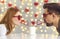 Funny young couple sipping drink through heart-shaped straws on St Valentine`s Day date