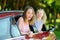 Funny young girls sticking their heads out the car window looking forward for a roadtrip or travel