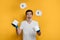 Funny young man is juggling rolls of toilet paper on yellow background