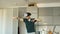 Funny young man in virtual reality 360 headset dancing in kitchen in the morning while listening to music and have fun