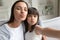 Funny young mom and preschooler daughter make selfie together
