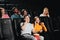 Funny young people talking by phone and laughing while sitting at the cinema