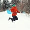 Funny young woman jump with snow shovel on rural road. Winter seasonal concept. Square