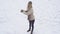 Funny young woman playing snow ball fight in winter. Girl snowballs game. Female in knit handmade hat and mittens with