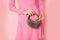 Fur Ear muff in woman hand, female personal accessories, unrecognizable person, pink background