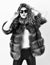 Fur store model enjoy warm in soft fluffy coat with collar. Woman wear sunglasses and hairstyle posing mink or sable fur