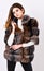 Fur store model posing in soft fluffy warm coat. Pretty fashionista. Fur fashion concept. Woman makeup and hairstyle