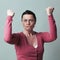 Furious 40s woman flexing her muscles up for female independence