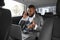 Furious african american businessman talking on phone in car