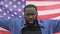 Furious afro-american man raising us flag, anti-racist rally, migrant crisis