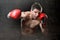 Furious man training boxing on gym with red fighting gloves throwing vicious punch