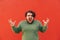 Furious overweight man with a curly hair, standing on a red background, feeling angry and frustrated, screaming, gesticulating and