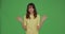 Furious young girl with spreading hands, ask what, feeling shock and misunderstanding on chroma key green background