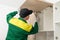 A furniture assembler adjusts the closing mechanism of the kitchen cabinet