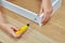 Furniture assembler tightens the into a wooden chipboard drawer using a screwdriver, ready-to-assemble furniture