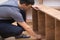 Furniture assembly and construction handyman placing shelves on wooden rack