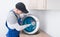 A furniture collector in a protective uniform, removes the protective film from the metal sink to insert it into a cut-out hole in