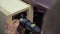Furniture maker drills the side surface of the cabinet, using a corner nozzle on the drill. Close-up
