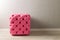 Furniture in the room. Pink pouf with decoration buttons in the