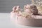 Furoshiki technique. Gifts packed in pink fabric and dried branches on white table, closeup. Space for text