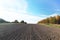 The furrows of the plowed field at the edge of the forest. Free soil for planting crops. Agricultural business. Technology vÑ–