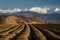 Furrows Row Pattern with Snowy Mountains in Background