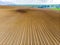 Furrows rows in a plowed field prepared for planting potatoes crops in spring.