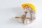 Furry, cuddly, cute little rabbit bunny toy in yellow helmet with hammer on white background with copy space