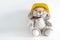 Furry, cuddly, cute little rabbit toy in yellow helmet on white background with copy space