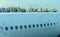 Fuselage of the narrow-body aircraft with white clouds and blue sky reflected in the portholes