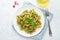 Fusili pasta with basil pesto and herbs, italian cuisine, gray stone background, top view