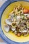 Fusilli Avellinesi pasta with clams and tomato in yellow and blue plate