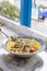 Fusilli Avellinesi pasta with clams and tomato in yellow and blue plate
