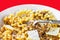 Fusilli con buco on white plate on red background