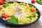 Fusilli pasta, fried eggs and tomatoes