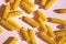 Fusilli pasta pile on pastel pink surface. Cute shape of raw, uncooked pasta on blight pink background.