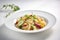 Fusilli pasta with vegetables on white plate