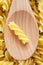 Fusilli Pasta in wooden spoon background full frame.