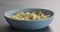 Fusilli pesto pasta in blue bowl on concrete background