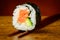 Futomaki sushi roll on chopsticks