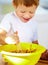 The future of the culinary arts. A little boy covered in dough and flour.