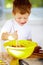 The future of the culinary arts. A little boy covered in dough and flour.