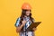 future engineer hold clipboard. safety work expertise. teen girl in protective hard hat