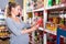 Future mother is reading structure of product on shelves