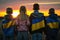 Futures of Freedom: Children with Ukrainian Flags Gazing at Sunset, a Hopeful Symbol of a Brighter Tomorrow