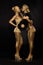 Futurism. Creativity. Glossy Golden Women with Vinyl Record over Black. Shiny Gilded Bodyart