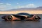 A futuristic car is shown on a desert plain. AI.
